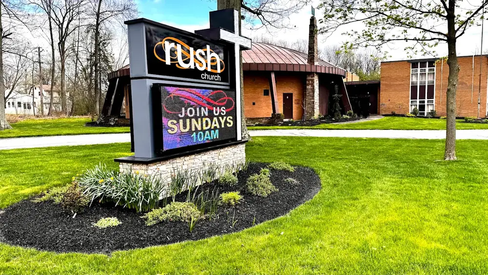 The Rush Church sign and building on Glenwood Ave, with a lawn and flower bed in front